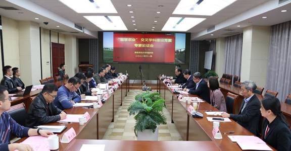 A group of people sitting at long tables in a conference room  Description automatically generated with low confidence